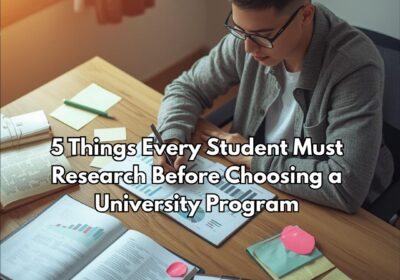 A university student researching college programs on a laptop surrounded by documents and a checklist