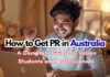 Indian student holding Australian PR documents with Sydney Harbour Bridge in background